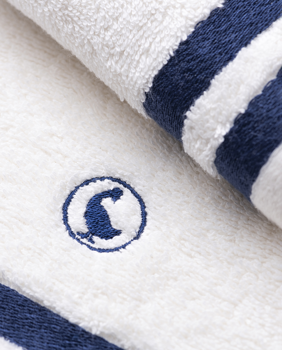 100% cotton toilet towel (Weight 500 g m²). Plain cotton bath towel with embroidered logo and red and blue border. Extra soft and highly absorbent. Measurements: 30*50cm